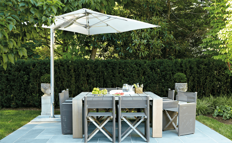 Natural materials lend this dining area an appealing simplictiy. The cantilevered shade is by Tuuci