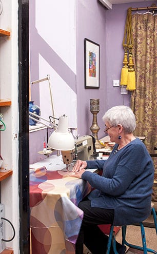 Seamstress Pip is kept busy at her sewing machine. The curtains behind her were made using an Etro fabric