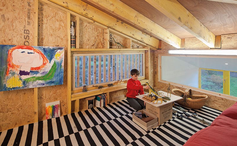The mezzanine, nicknamed ‘the treehouse’ by the children, has been left with its rough-and-ready OSB boards exposed, which suits the look and feel of the play area. 