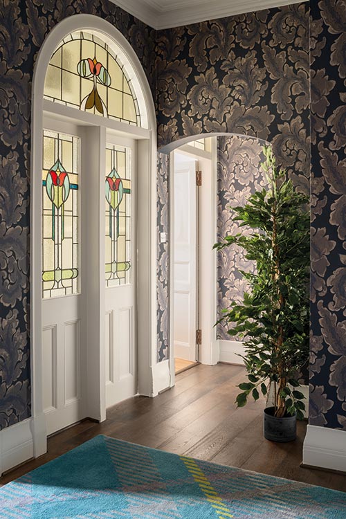 The arched doorways of the entrance hall are reflected in the elegantly curved antique bureau that was left behind by the previous owner