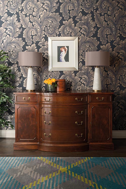 The arched doorways of the entrance hall are reflected in the elegantly curved antique bureau that was left behind by the previous owner