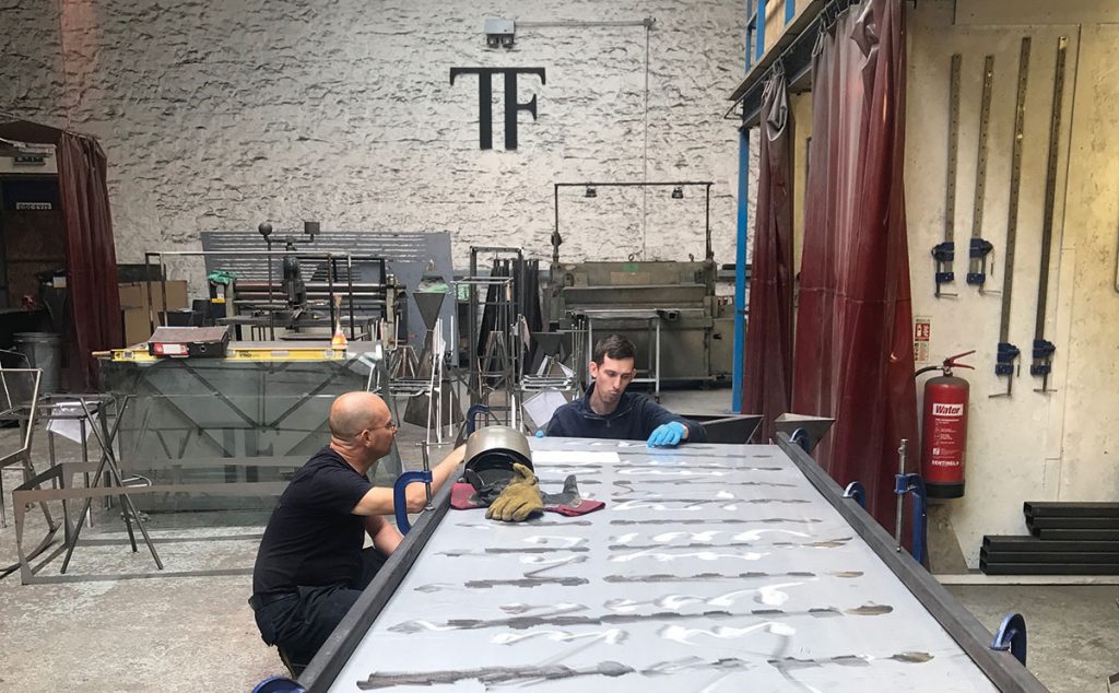 Nigel, chief engineer, and Matthew, senior designer, working on a bespoke dining table in the Wiltshire workshop