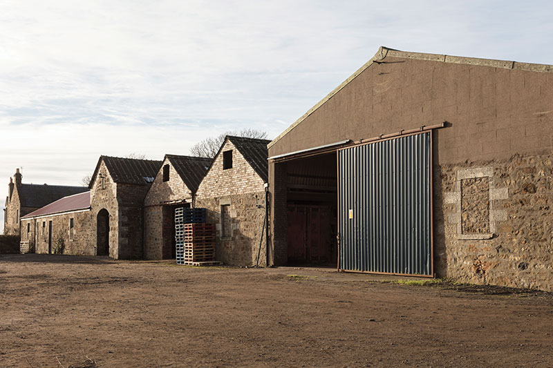 the working farm is bustling with tractors, trailers and lorries