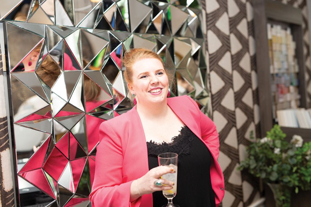 woman-in-pink-jacket-in-front-of-geometric-mirror