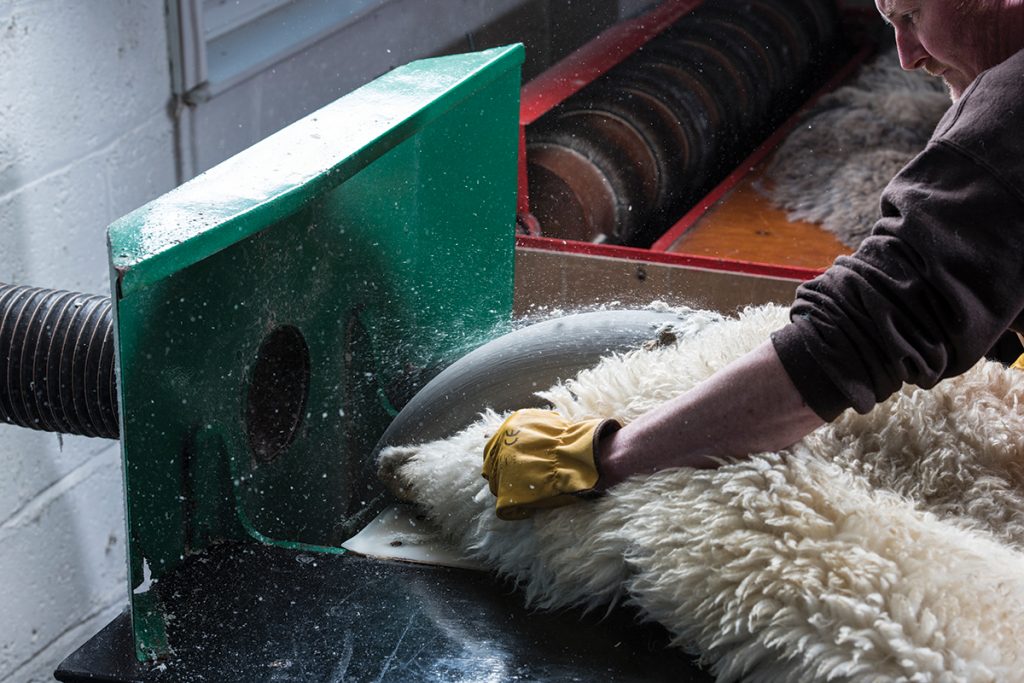 Pete-uses-a-buffing-wheel-made-of-Scottish-granite-to-give-the-leather-side-of-the-sheepskin-its-soft,-almost-sueded-finish