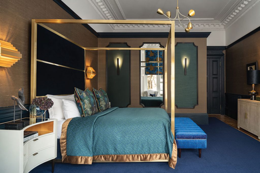 dark-bed-room-with-blue-carpet-and-gold-four-poster-bed