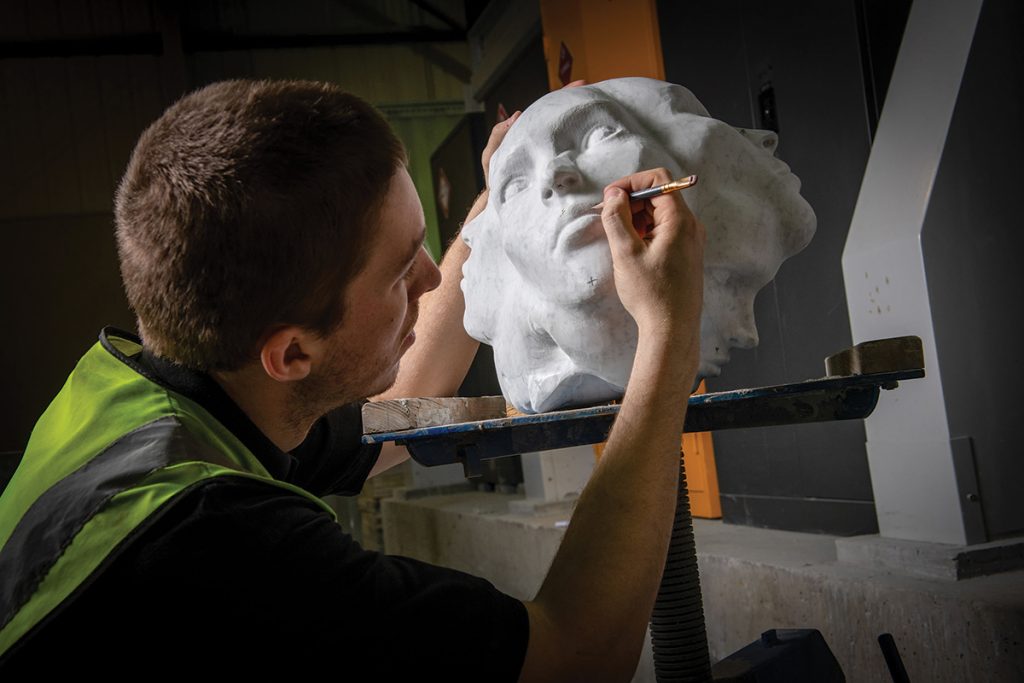 man-restoring-a-stone-head