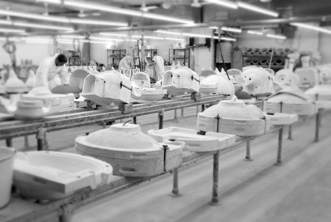 Moulds for toilets lined up in the factory. Black & white image