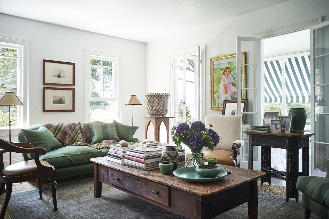 living room, green sofa, coffee table with lots of books 