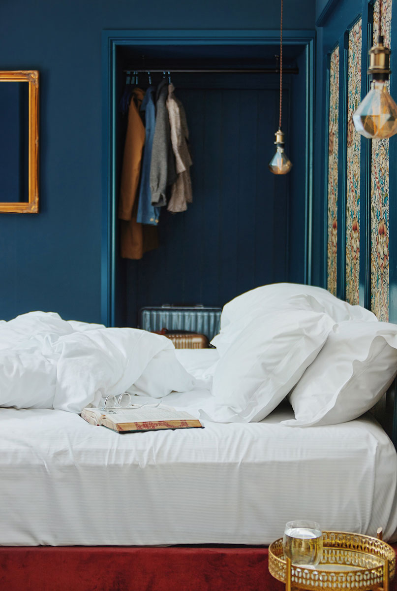 Blue bedroom with intricately patterned wallpaper