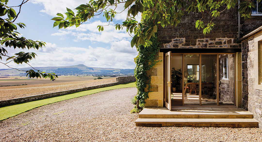 view to working farm, bright blue skies and view inside to dining area 