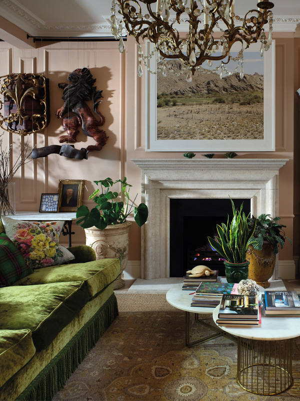 Interior design by TG Studio | Photography by Philip Vile Interior of a living room with a green sofa, white fireplace with coffee table and artwork on the wall