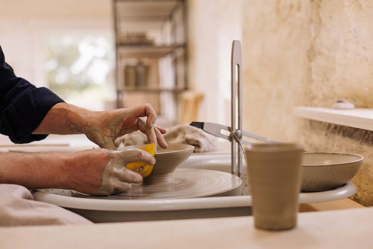 Potter moulding clay on potter's wheel