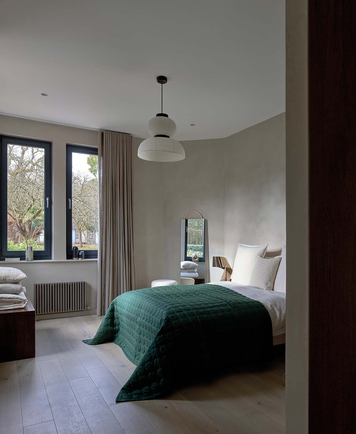 Bedroom of Miller's Cottage in South Lanarkshire. Bed with emerald green bedspread and neutral decor