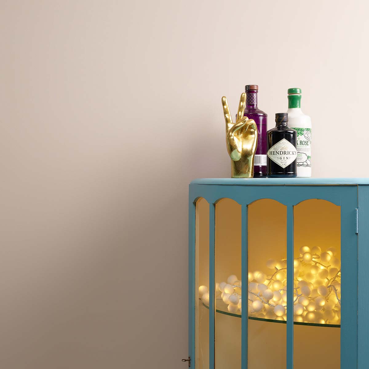 Blue drinks cabinet in front of a wall painted in Frenchic Paint shade 'Cool Beans'