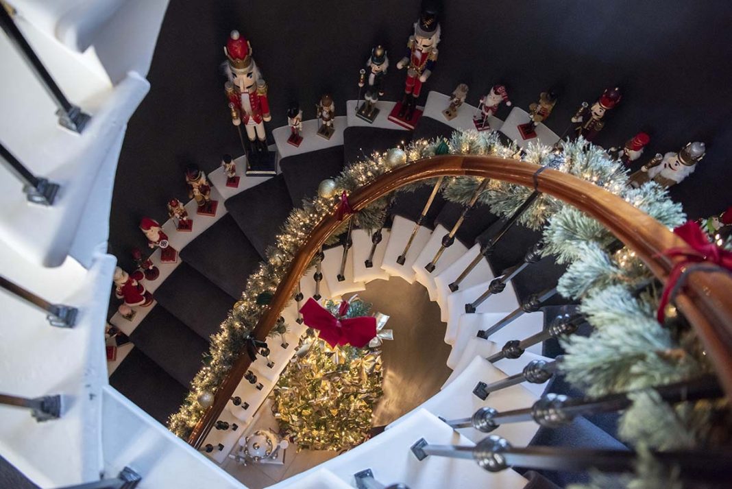 a curving staircase decorated for Christmas