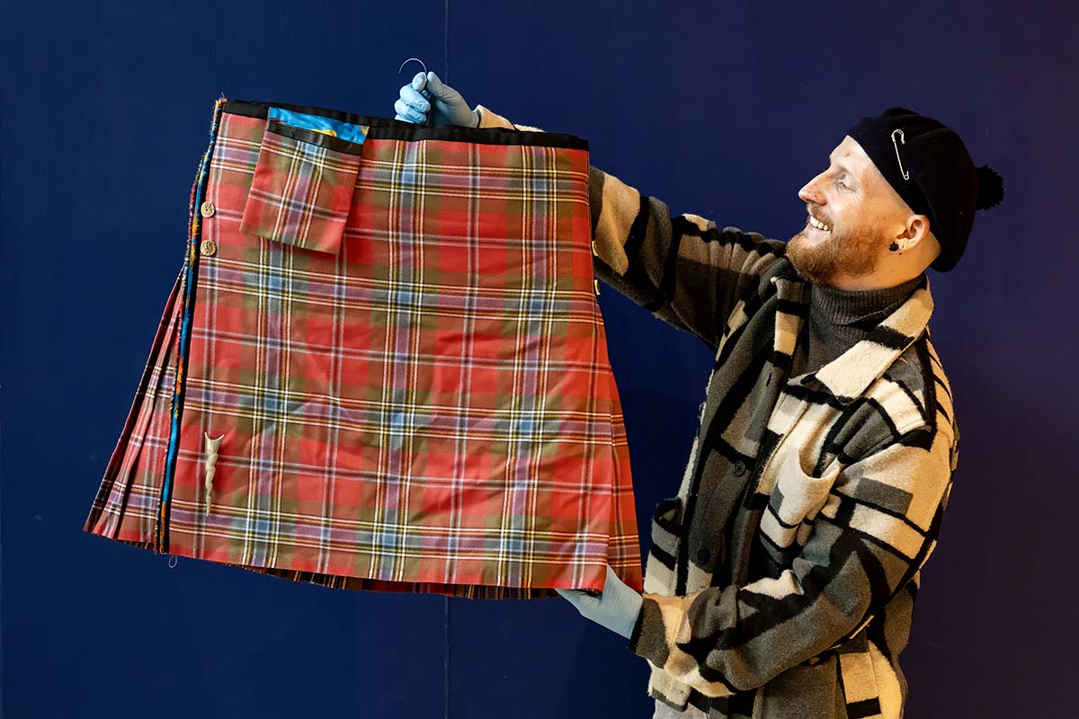 A man holds up Billy Connolly's kilt