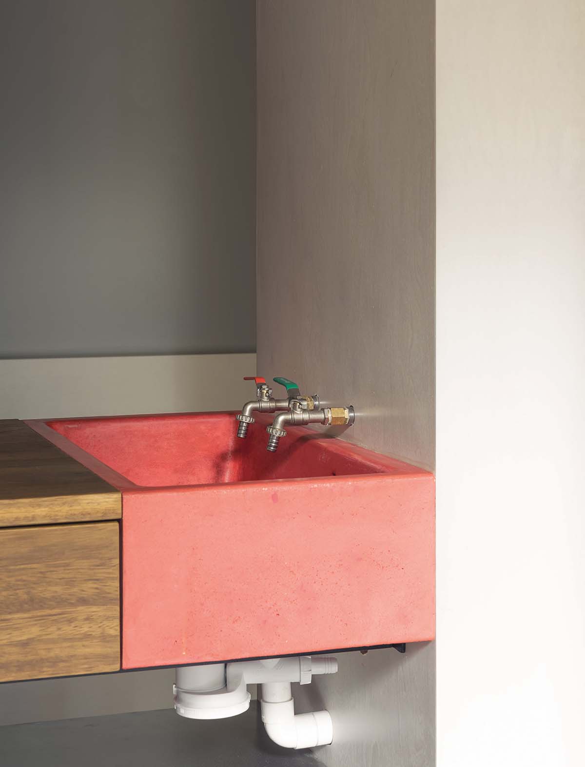 Red sink with wooden countertop