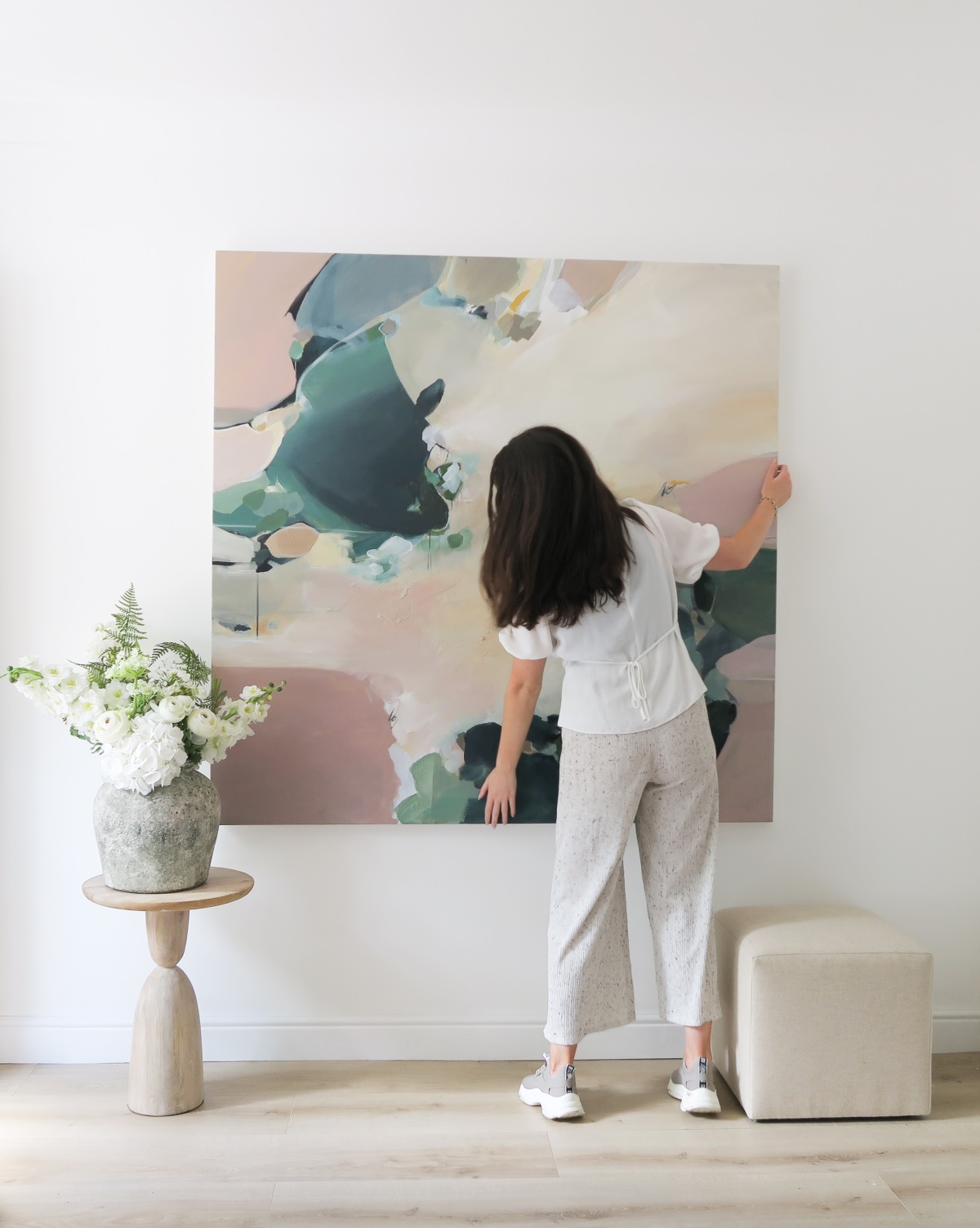 Christina of Christina Boyle Studio in front of one of her paintings on canvas 