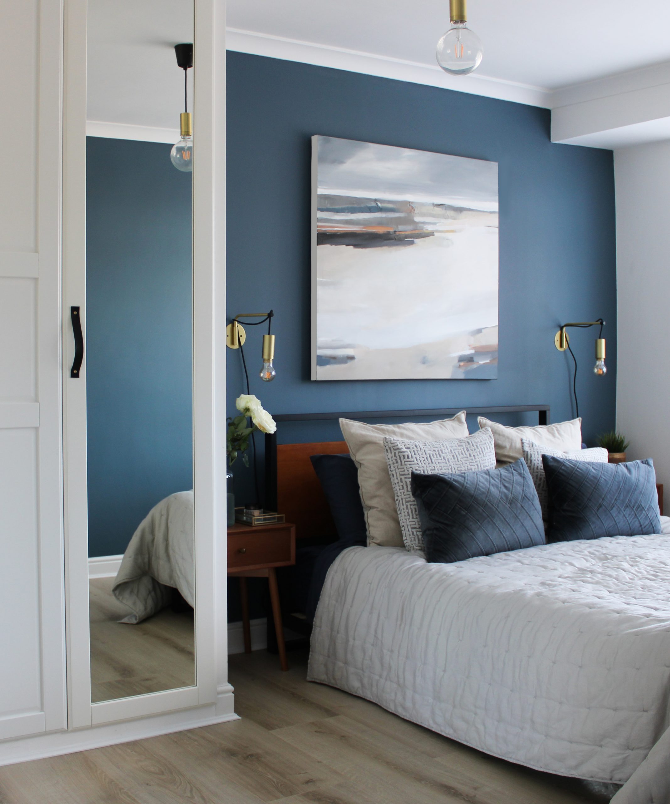 Christina Boyle Studio canvas hung above bed on blue wall