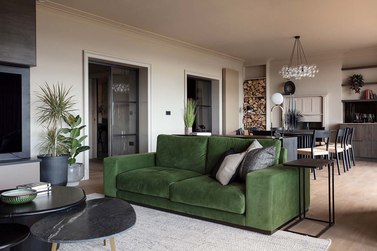 green sofa in open plan living space with black coffee tables