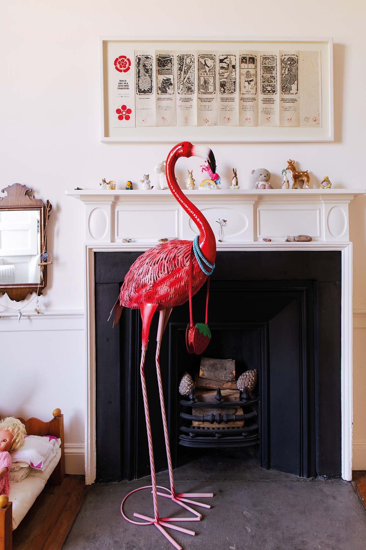 A large flamingo sculpture stands in a child's bedroom, in front of a fireplace