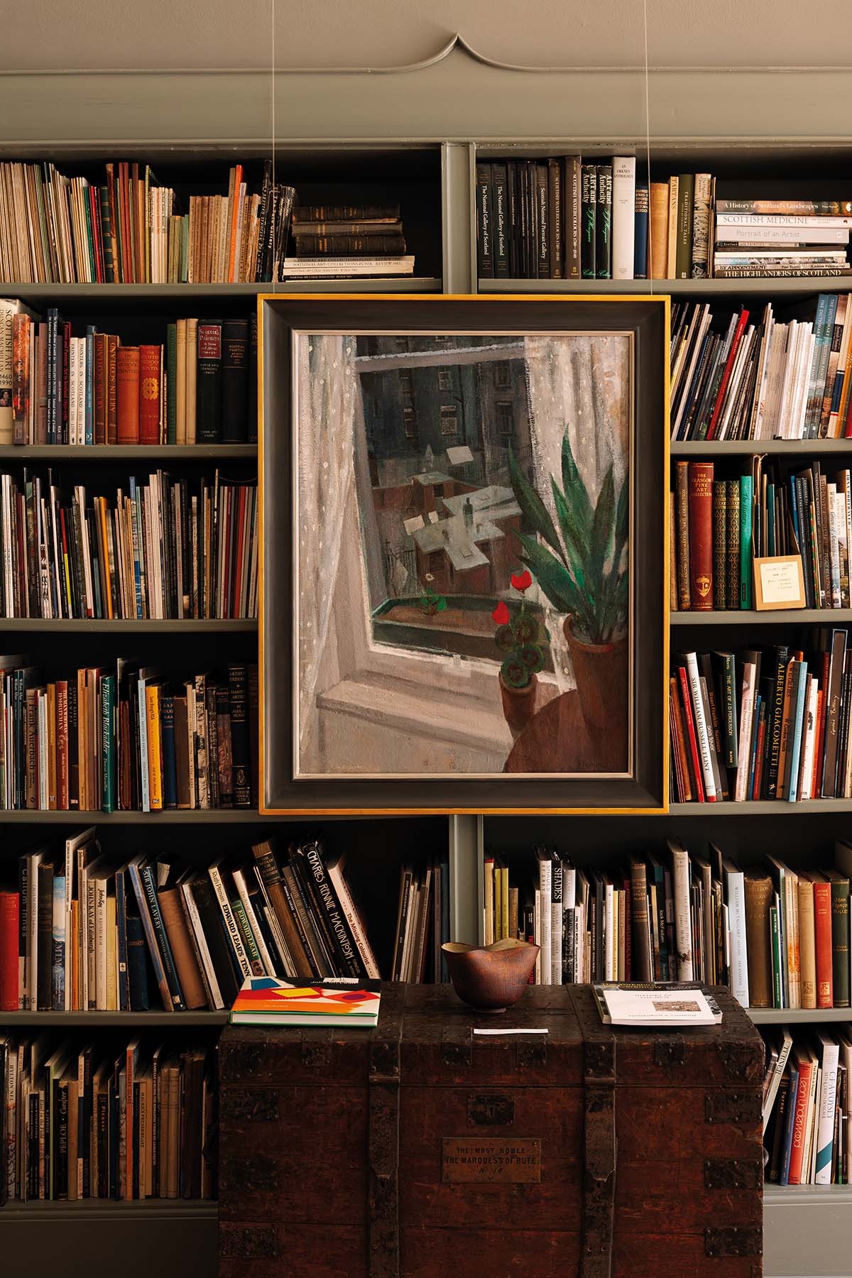 A painting displayed against the backdrop of bookshelves
