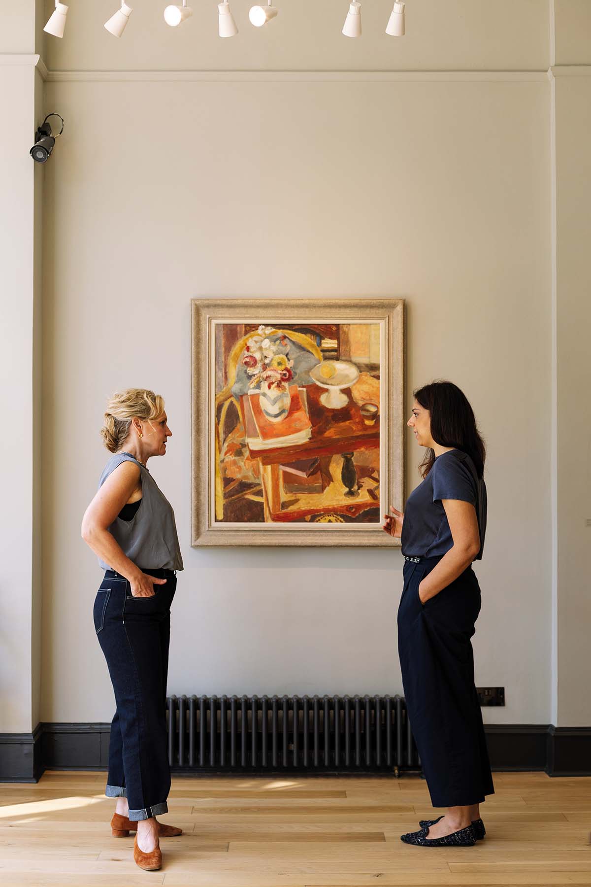 Emily Walsh and Camilla Riva stand in front of a painting in the Fine Art Society