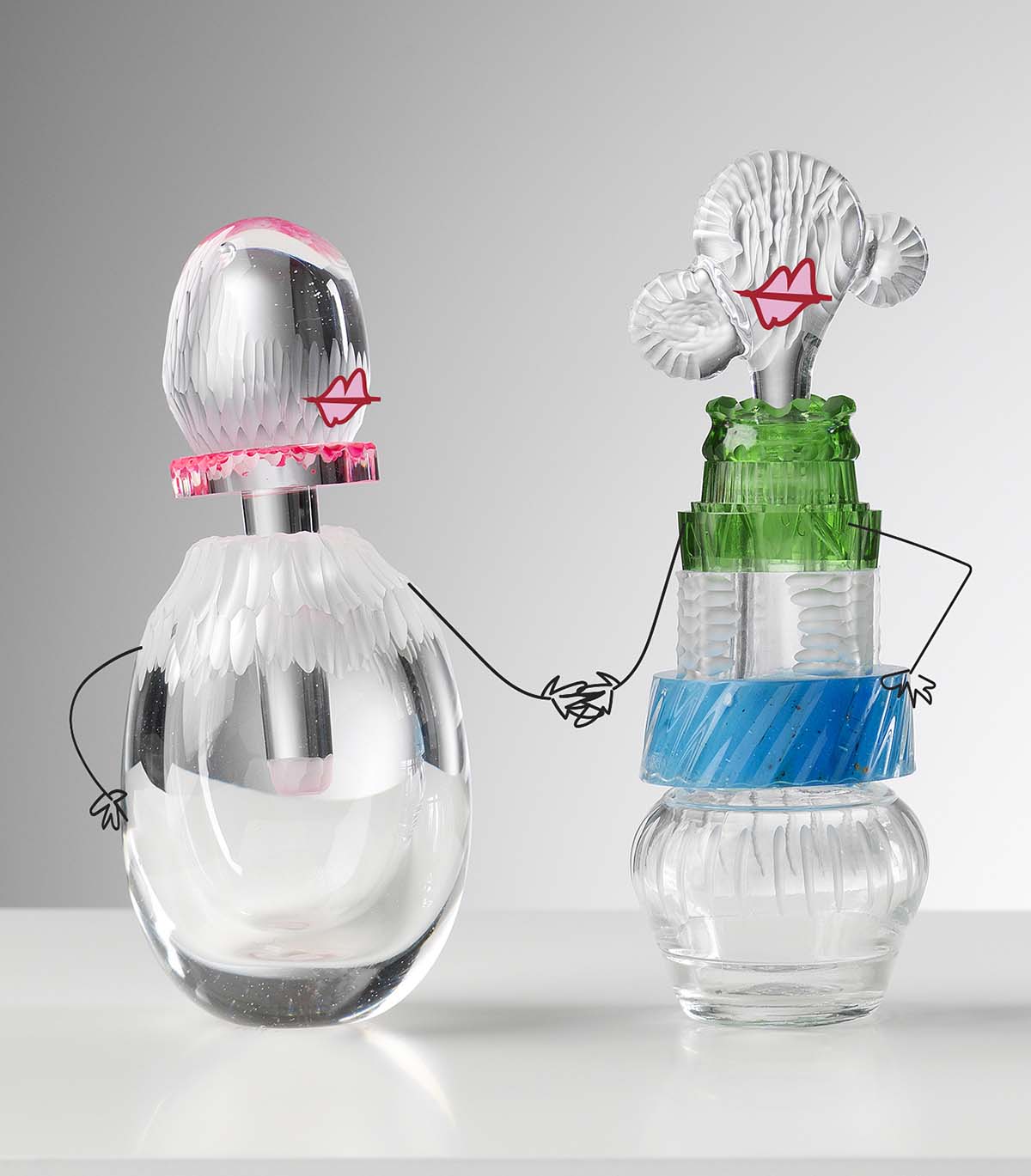 Two glass sculptures in the shape of women, with illustrated lips and arms, holding hands