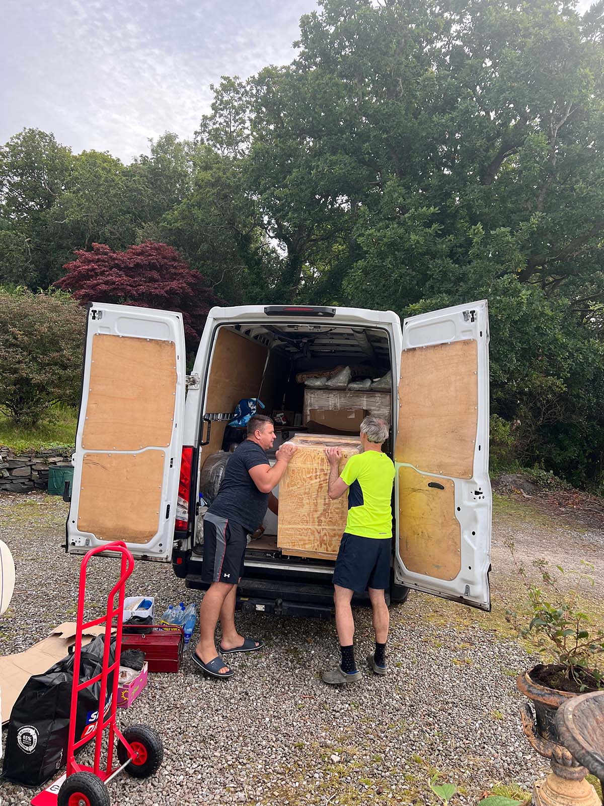 Builders unload a kitchen unit from the back of a van