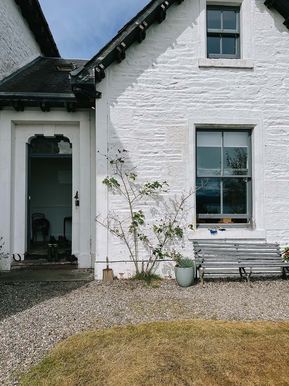 an external view of a period property, painted white with a black roof