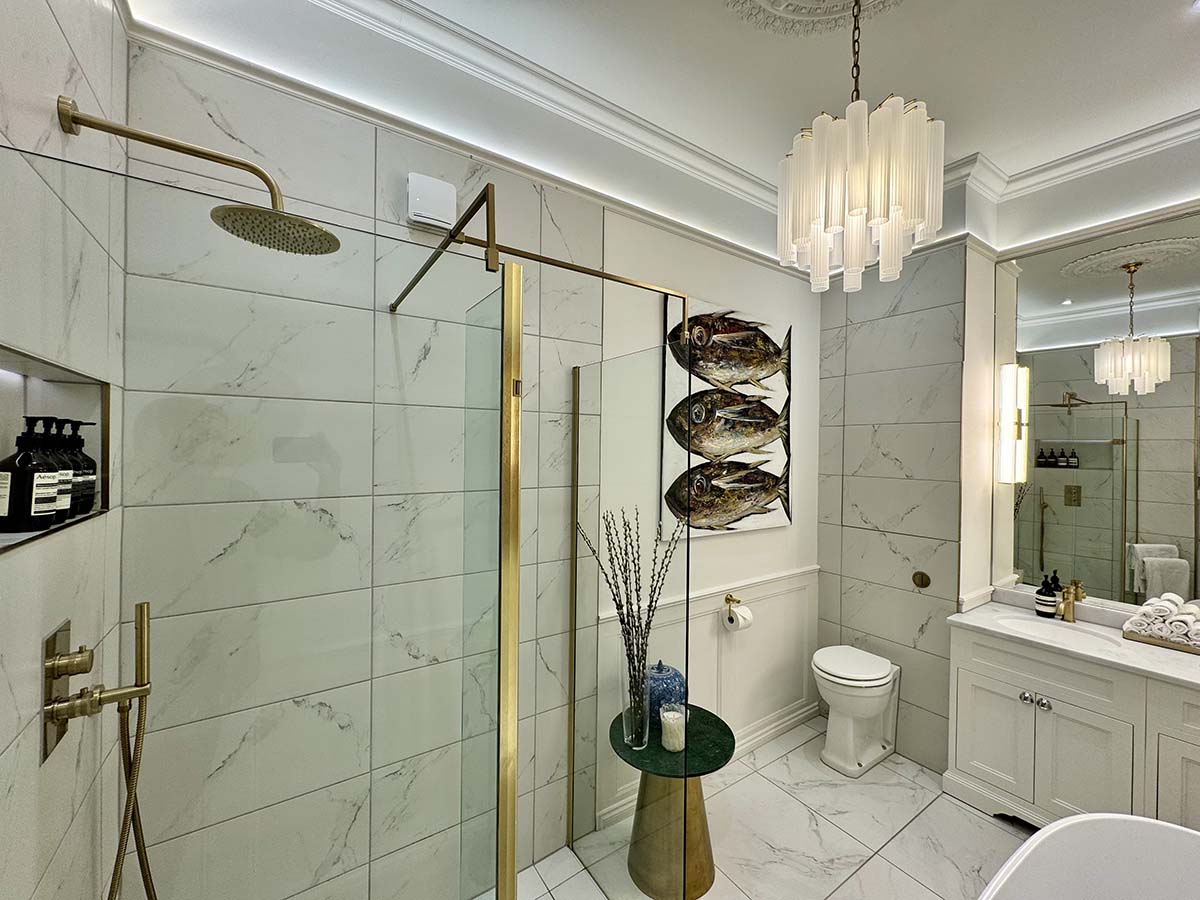 a luxe bathroom, with while tiles and gold finishes