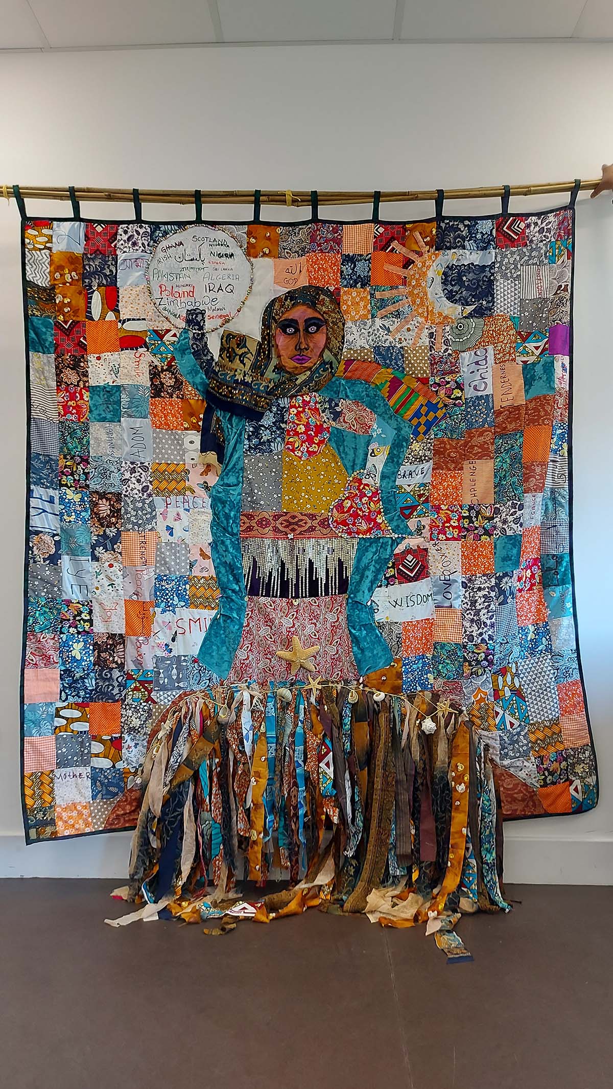 A large tapestry showing a woman made of patchwork squares