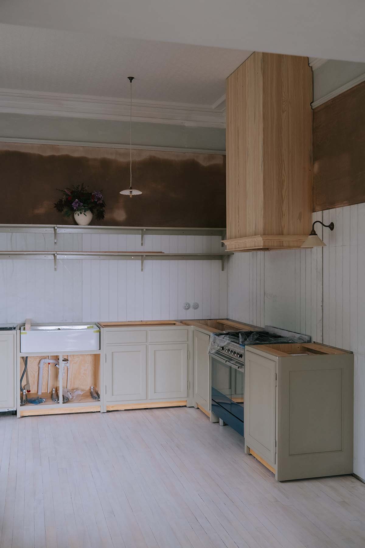 a kitchen in the middle of a renovation, with newly installed cabinetry