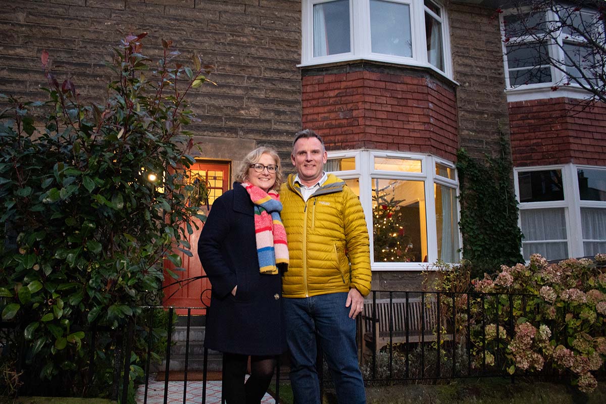 a couple stands in front of a terraced house