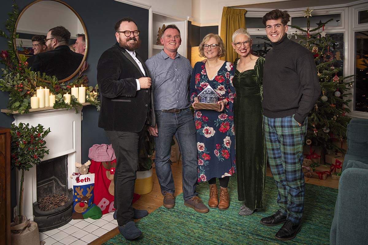 The judges of Scotland's Christmas Home of the Year stand in the winning home with the winning couple. A woman holds a trophy.