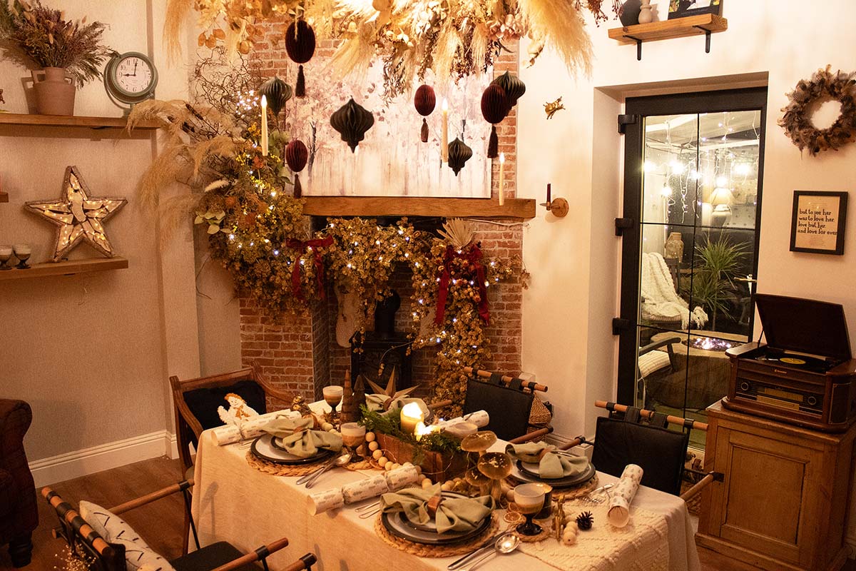 a dining room with a fireplace and dining table decorated with natural materials for Christmas