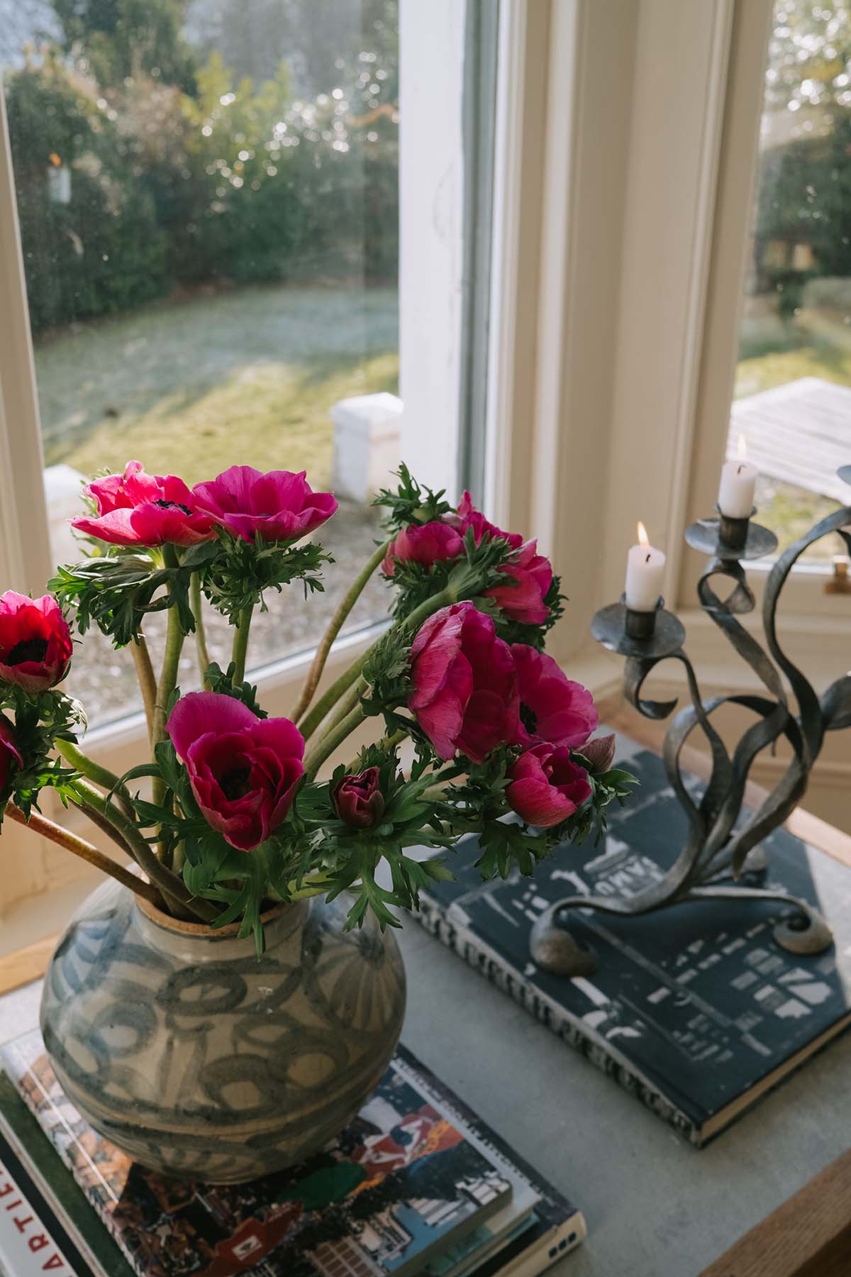 a bunch of pink flowers in a patterned vase, sitting in a windowsill