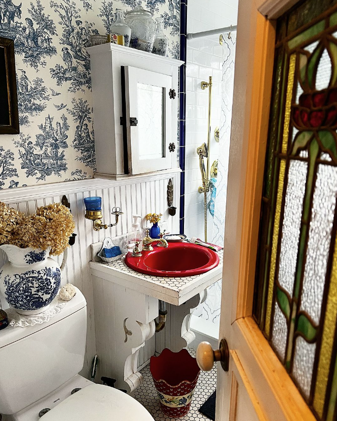 Unexpected red sink in a blue bathroom
