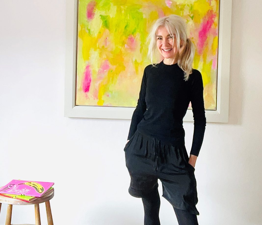 Photographed is Alison McWhirter beside her painting, titled 'Yellow, Yellow, Yellow - It Eats Into the Leaves', which is on show in the KUDIRKA art space