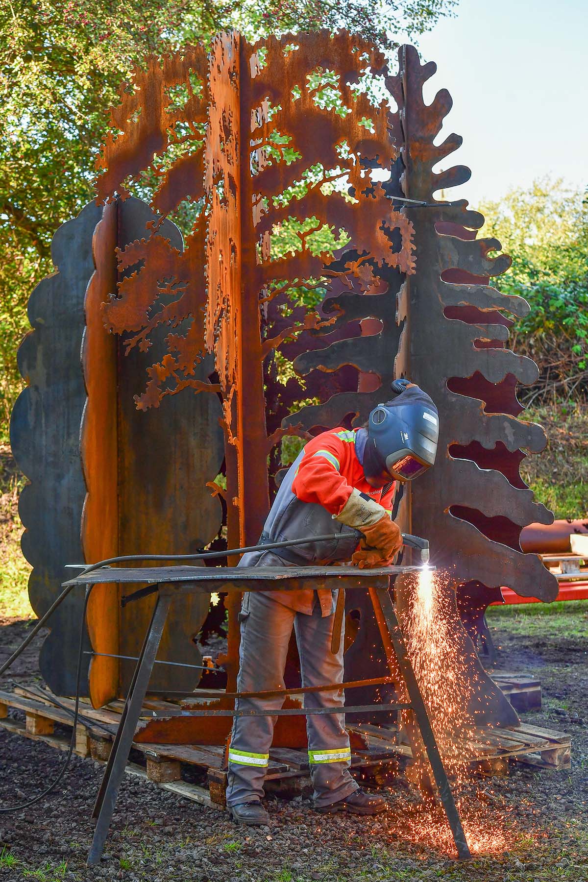 Andrea Geile welding her 'Amongst the Trees' exhibition in her summer garden