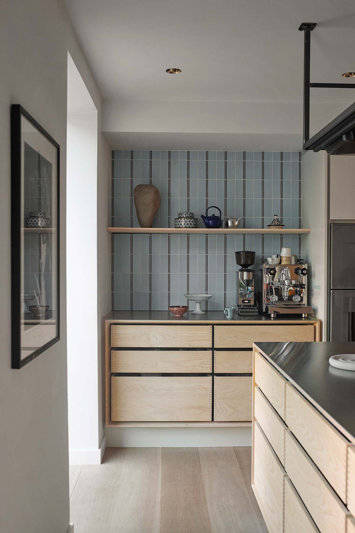 Kitchen food prep area, with wood cabinetry and blue tiling featured in a bespoke Garde Hvalsoe design