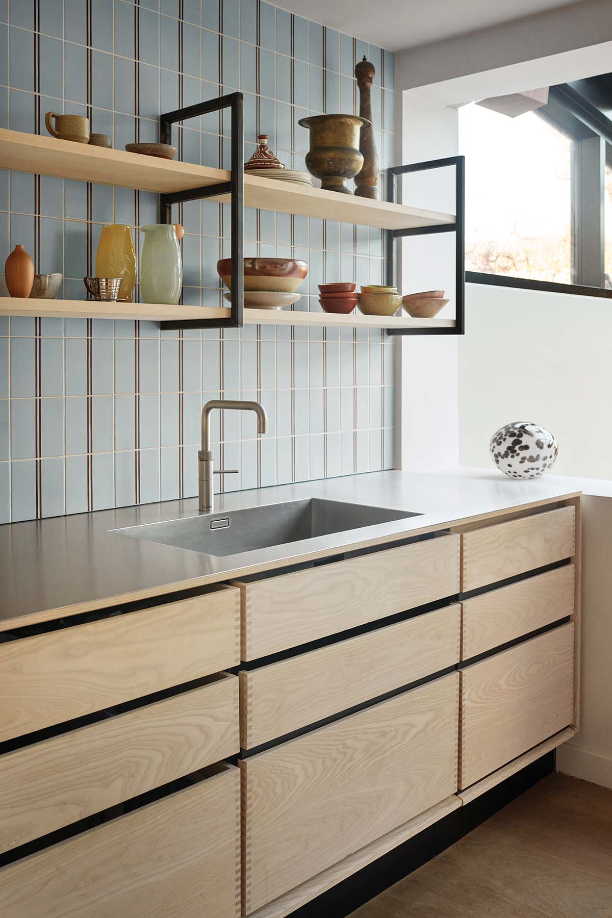 Kitchen sink and washing area, with white cabinetry, wood shelving and chrom countertops featured in a bespoke Garde Hvalsoe design