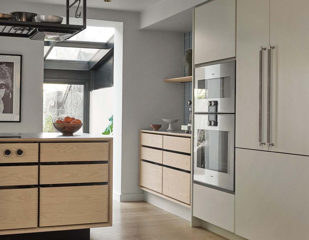 Kitchen oven and cooking area, with white cabinetry featured in a bespoke Garde Hvalsoe design