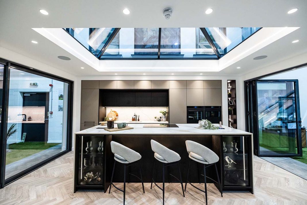 bifolding doors with kitchen setup white stools and skylight