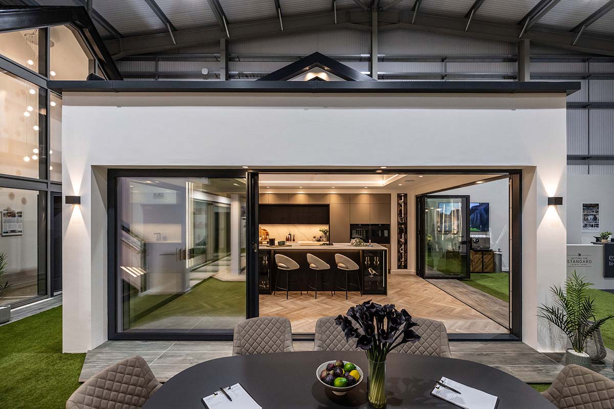 external home with bifolding doors leading into the kitchen area