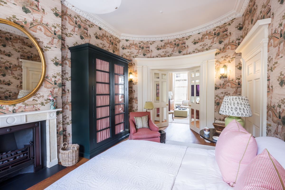 basement renovation with french doors, traditional wallpaper and antique bed and wardrobe