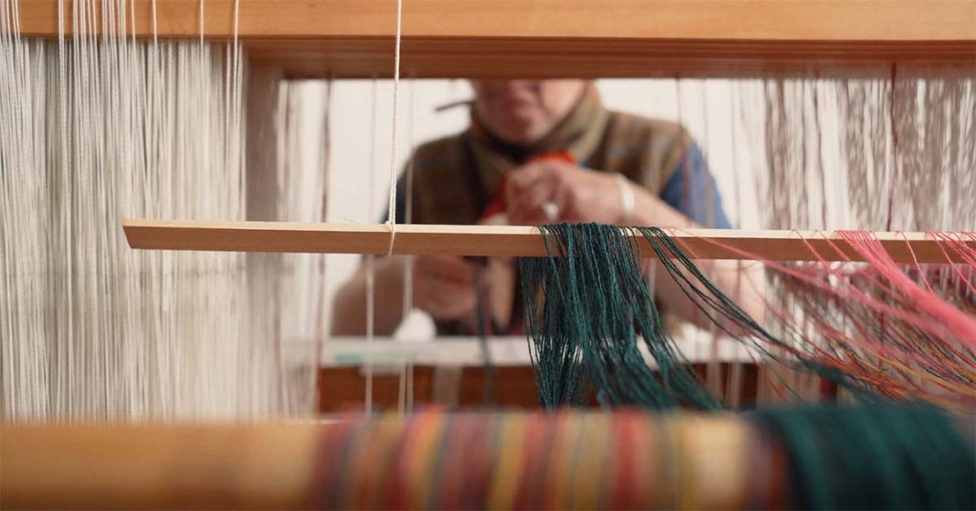 Textiles weaver and fashion designer working on a traditional weave