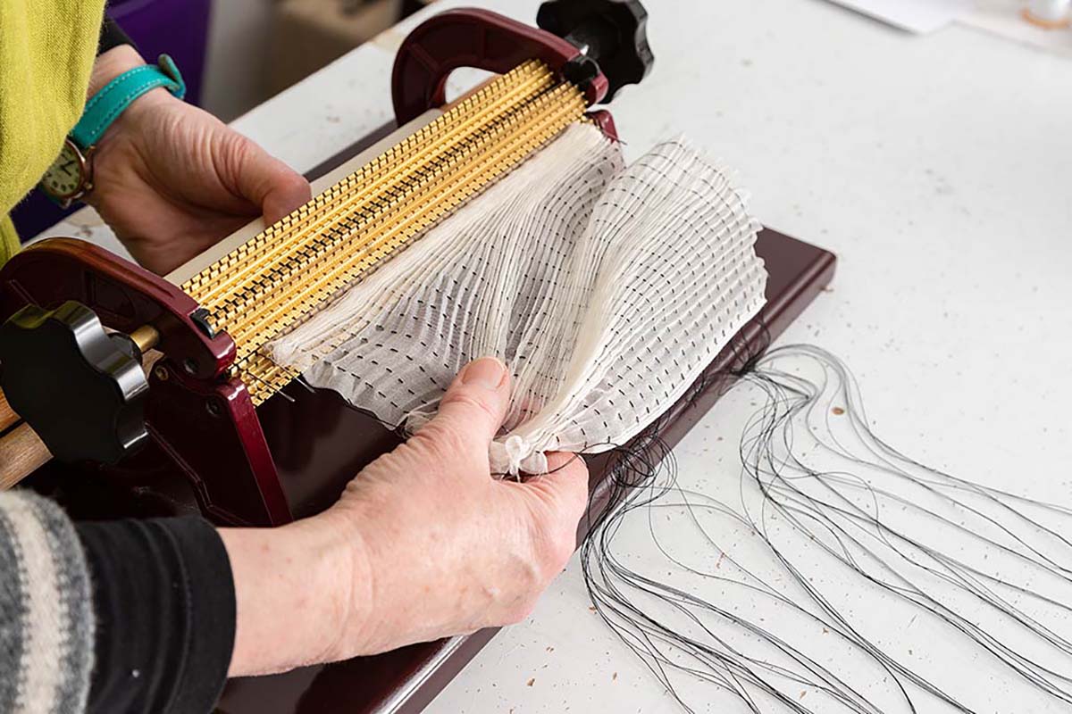 woman works on textile art in scotland