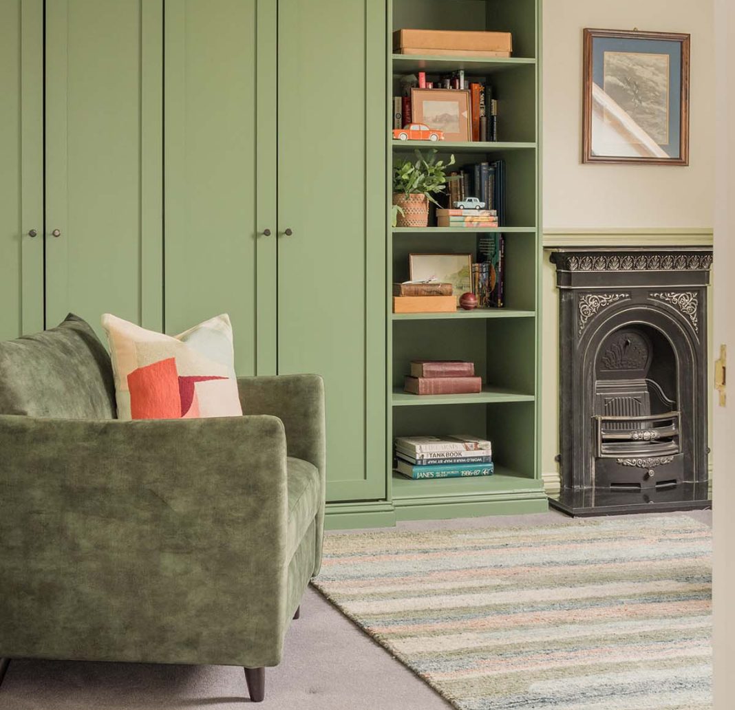 interior of a period property that has been redesigned with contemporary features in colours green with black traditional fireplace